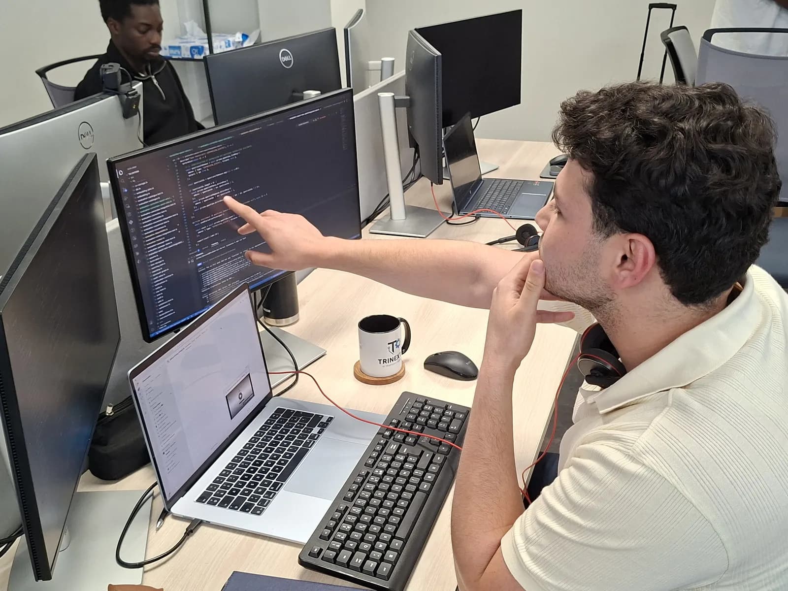 Un développeur de l'équipe montre une portion de code à l'écran